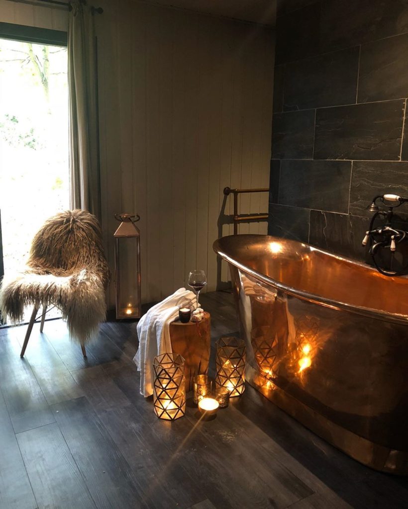 copper bathtub with fur accent and relaxing candles Bathroom Lighting Ideas