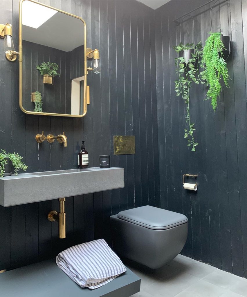 charcoal shiplap walls with gold accents and gray toilet Bathroom Lighting Ideas