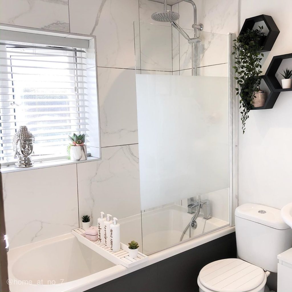 bathroom with white marble tiles on wall and charcoal fixtures