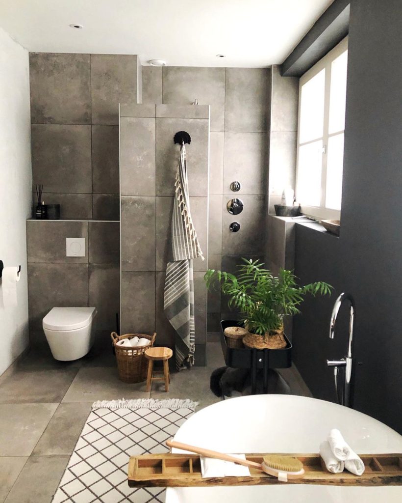 bathroom with farmhouse rug and gray stone tile on wall