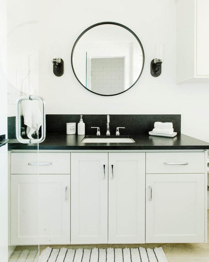 Black and white guest bathroom with black accents and black countertop