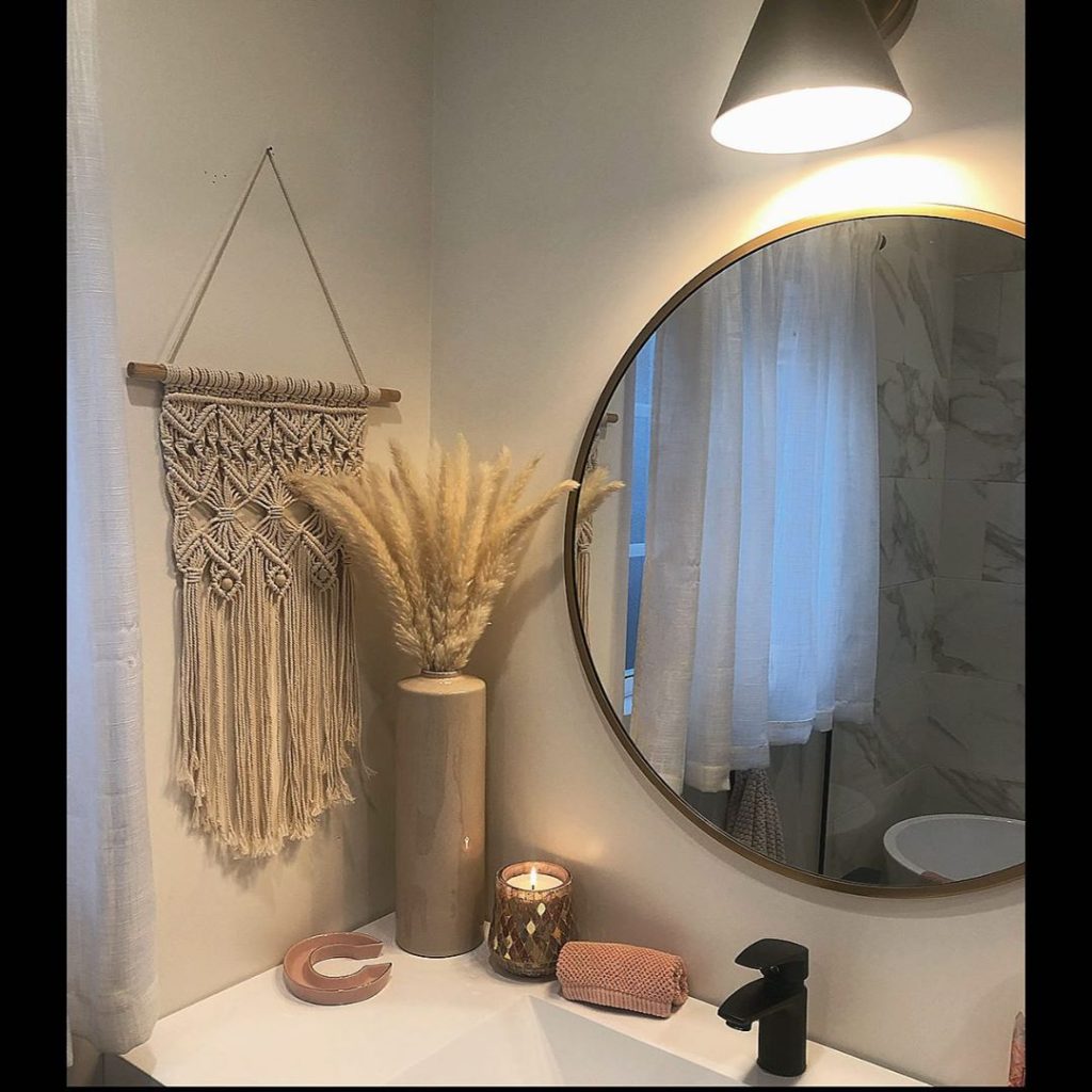 guest bathroom with macramé hanging and circular mirror