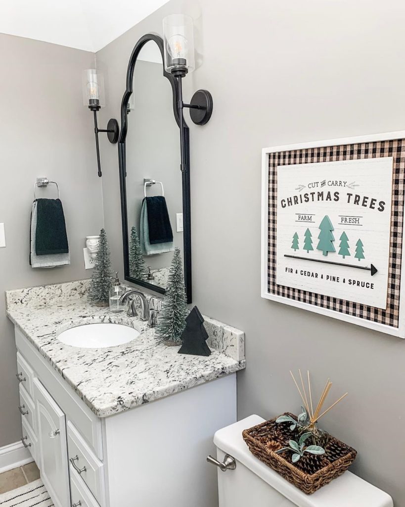 gray bathroom with blac kfixtues decorated for christmas