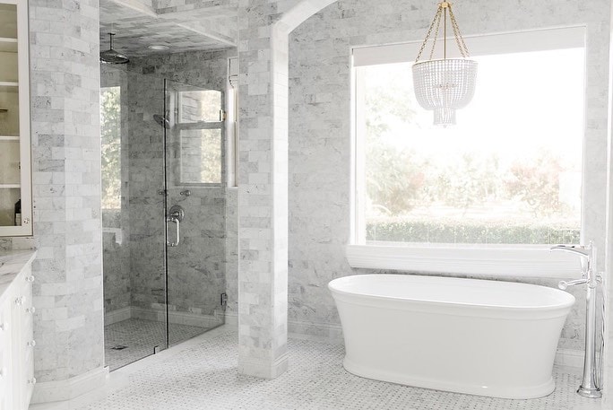 gray bathroom with chandelier and large window