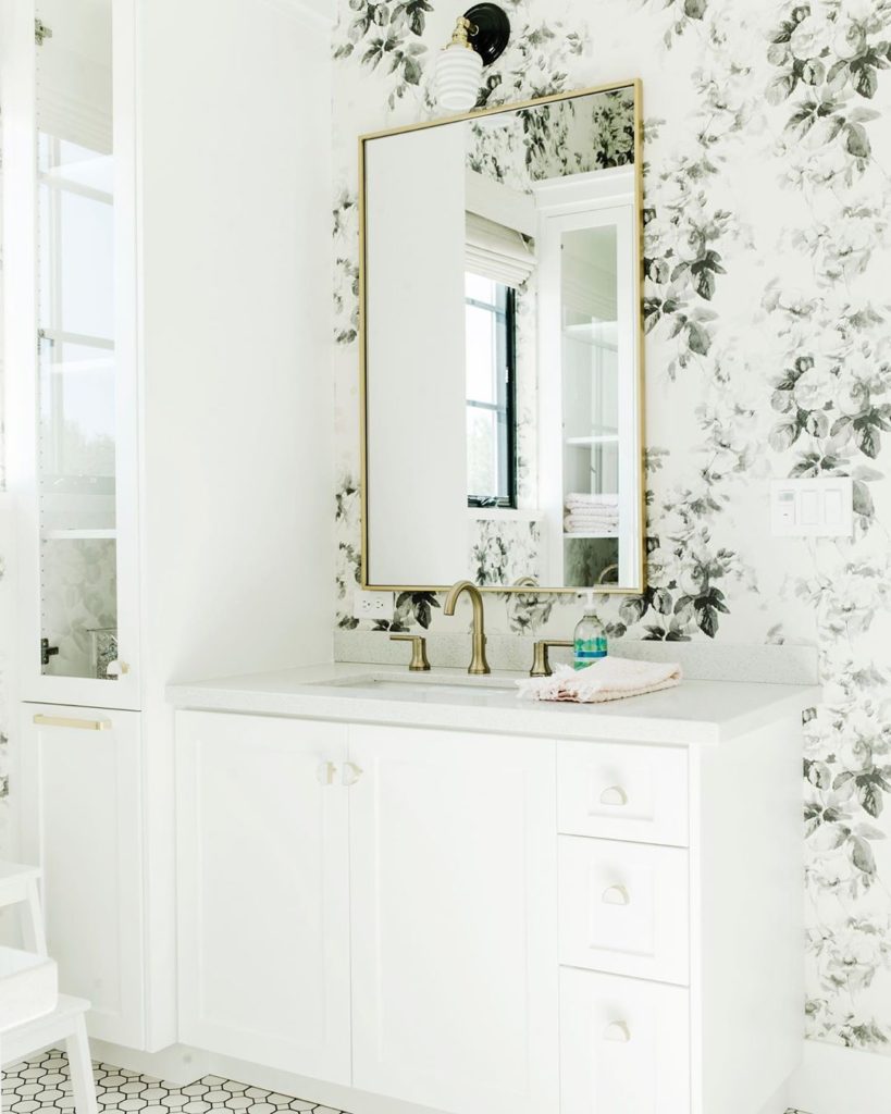 guest bathroom with floral wall paper and gold accented mirror