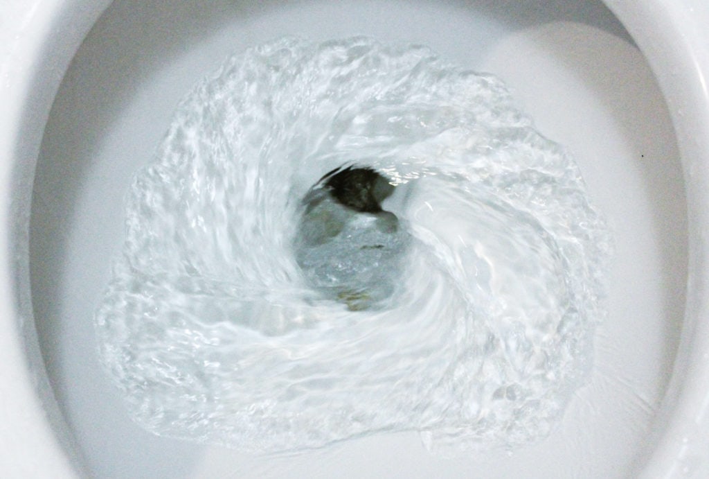 selective focus close up flushing toilet bowl for sanitary, Toilet, Flushing Water, close up, water flushing in toilet, A photo of a white ceramic toilet bowl in the process of washing it off. Ceramic sanitary ware for correcting the need with an automatic flushing device