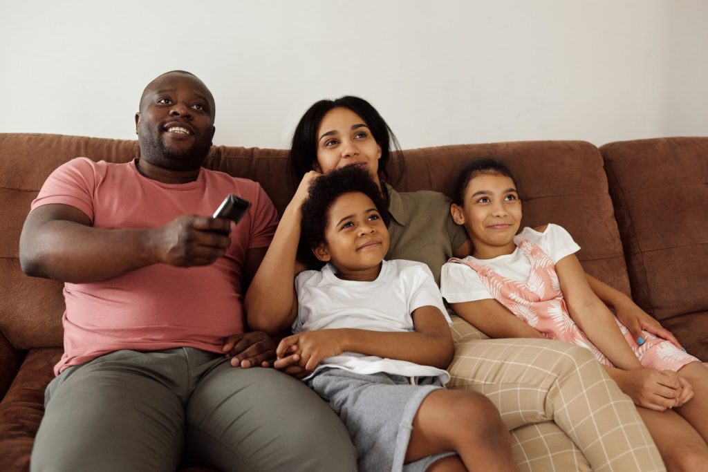 Family cuddling in the middle of couch