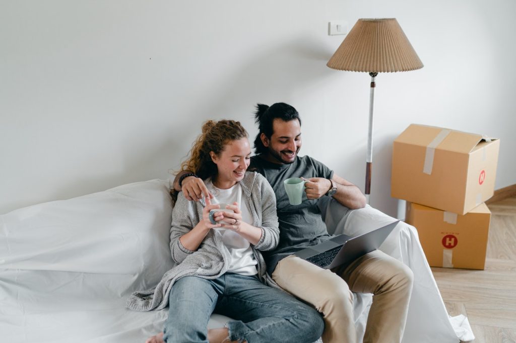 Couple cuddling in the corner of a couch