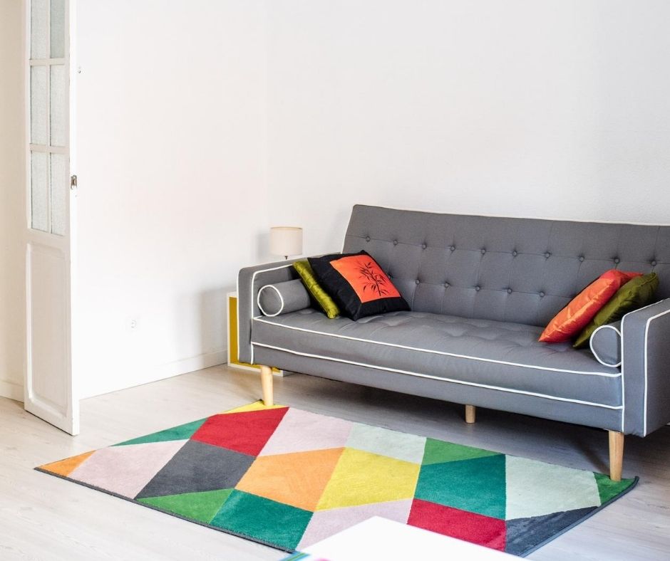 colorful rug under gray couch