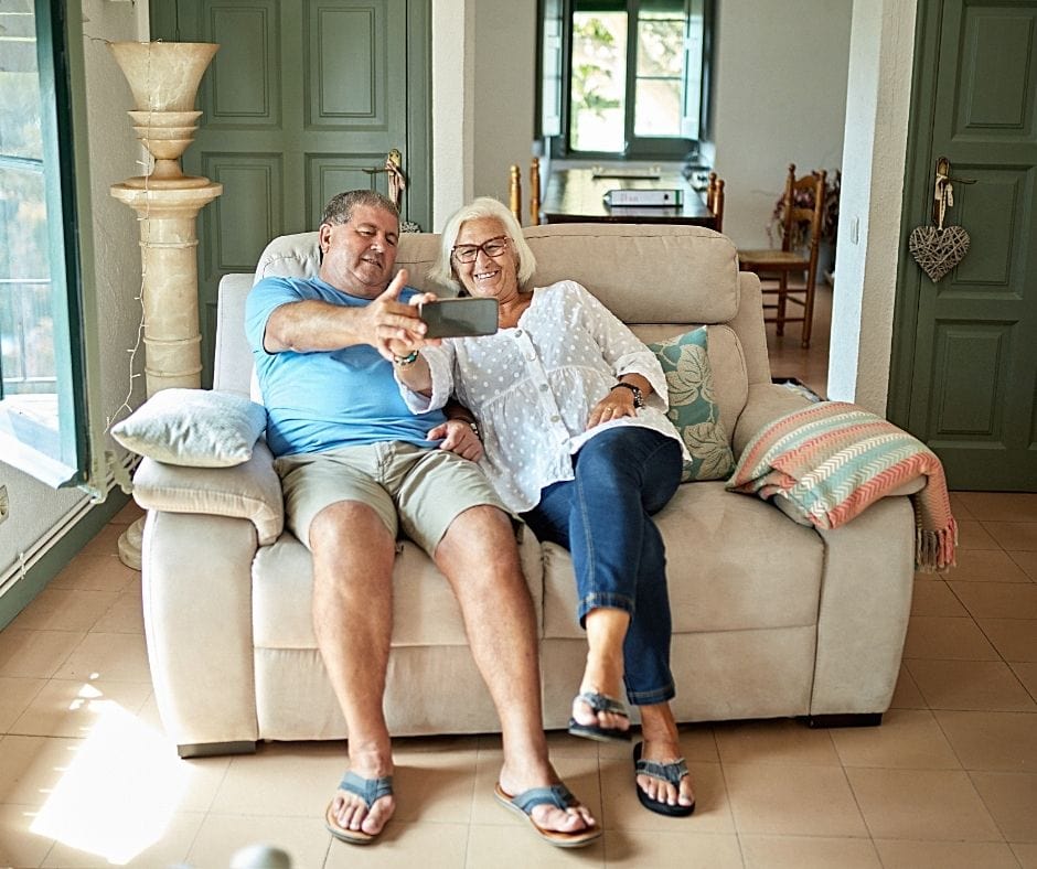 two elderly people sitting on and testing a double recliner to see if it is the best