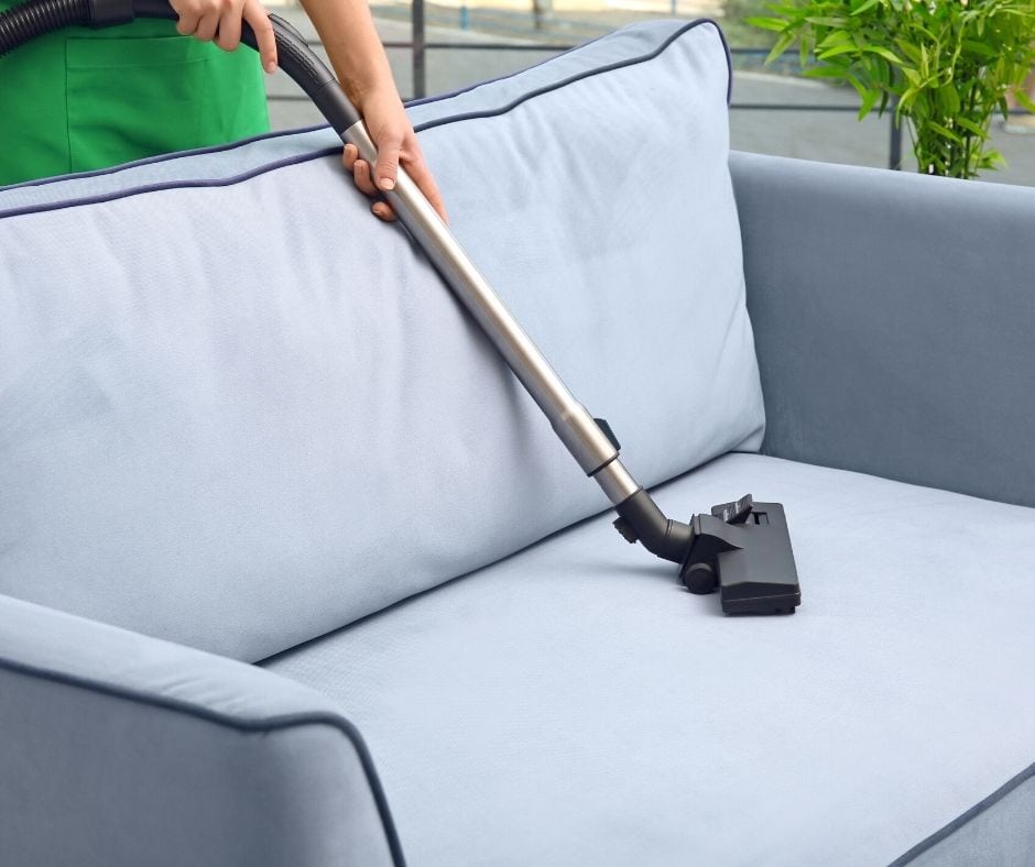 vacuuming a couch to remove water stains