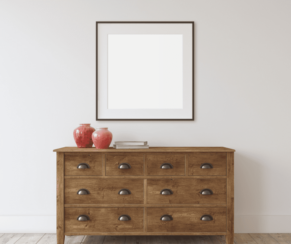 Wooden dresser below a wall frame