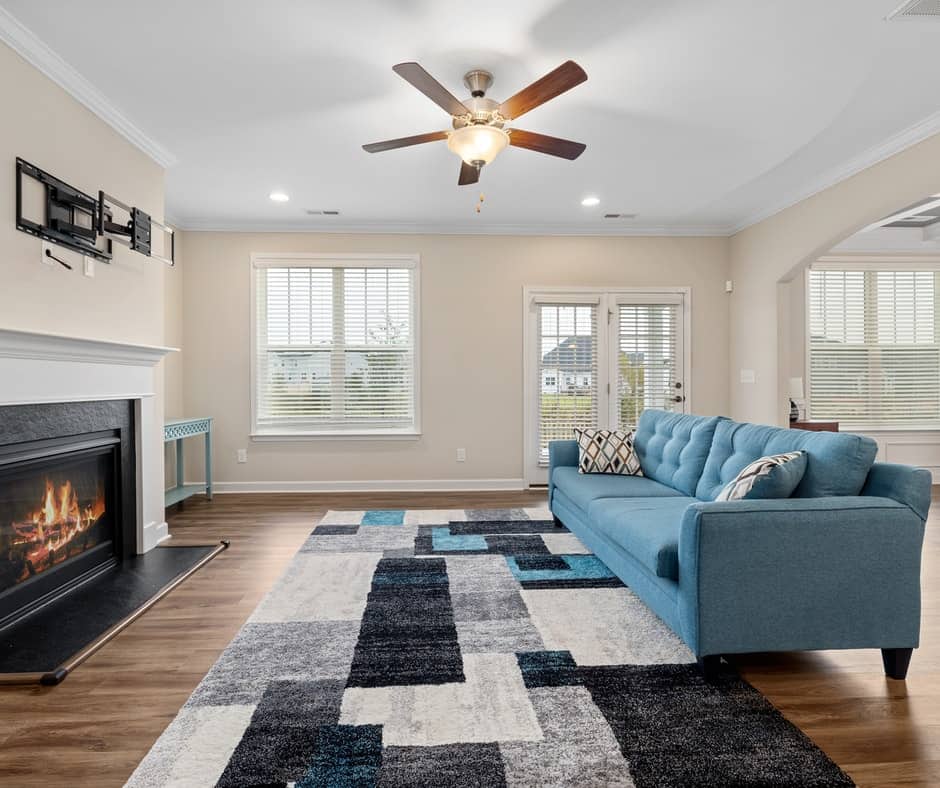 Living room with blue sofa, fireplace and window blinds