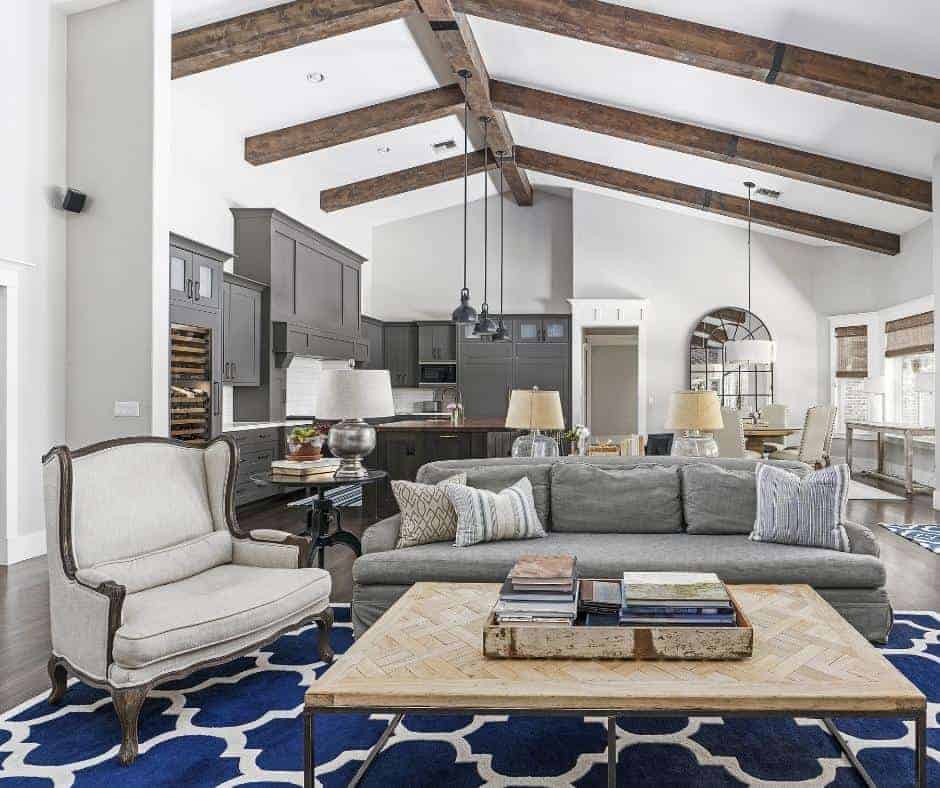 a blue rug under neutral couches in a living room