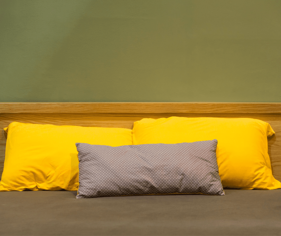 Brown bed with yellow pillowcase