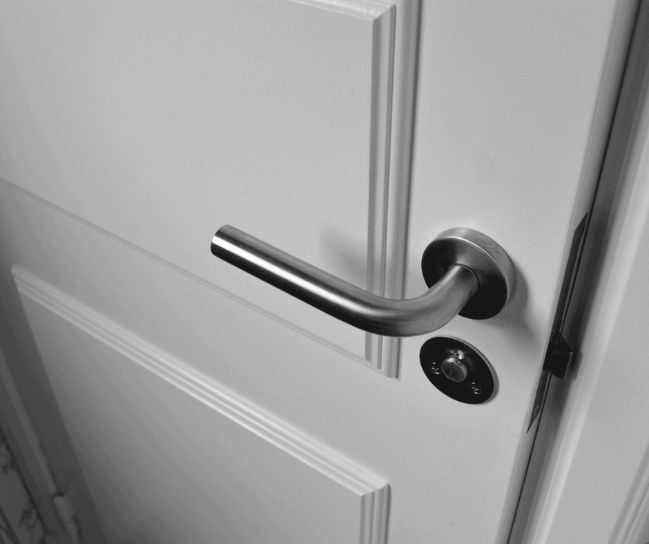 Close up of chrome door handle on white bedroom door