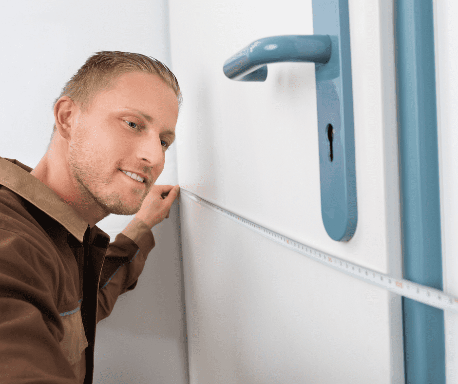 Man measuring a bedroom door using tape measure