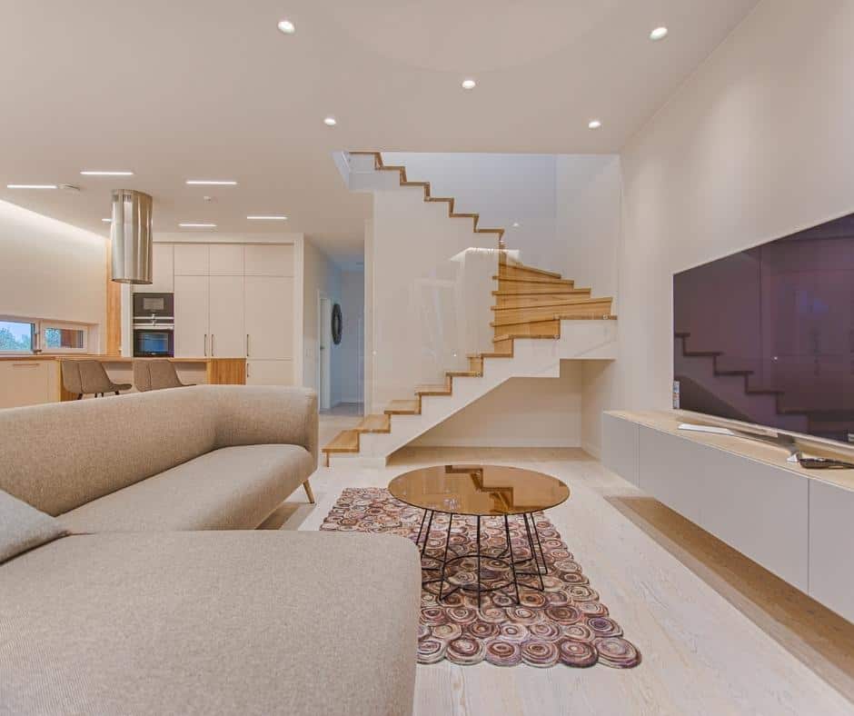 stunning living room with neutral couches and a purple rug