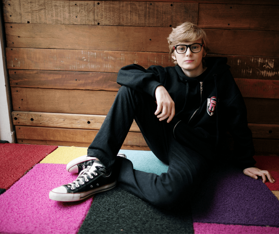 Boy sitting on multicolored rug