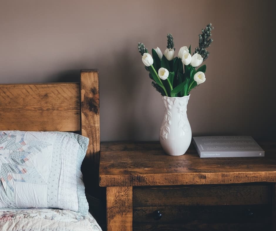 Simple rustic bed and side table with flower décor