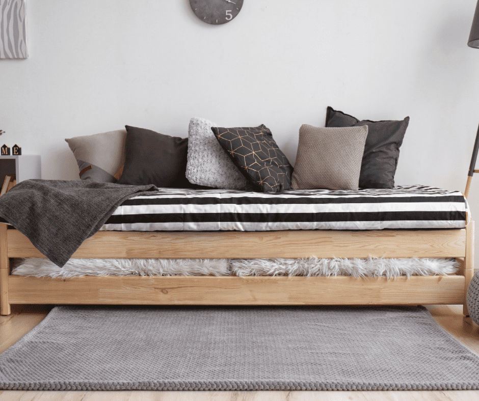 Simple wooden framed bed with rug beneath