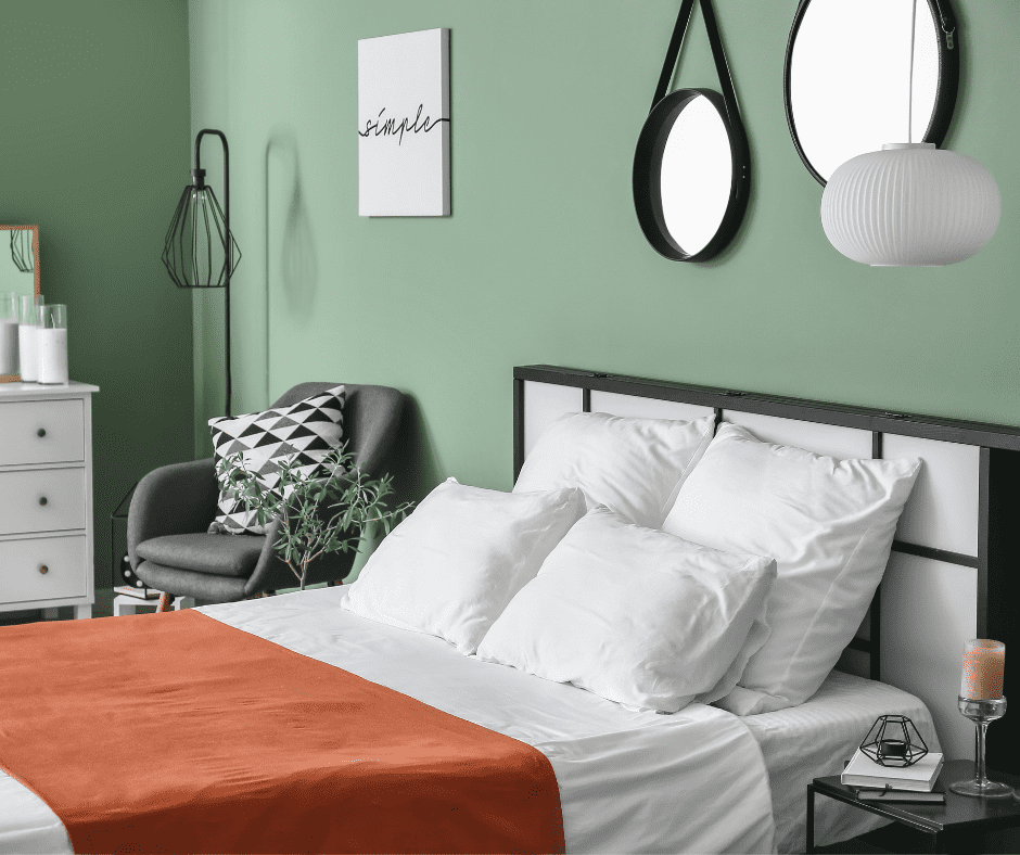 Black bed frame with moss colored wall