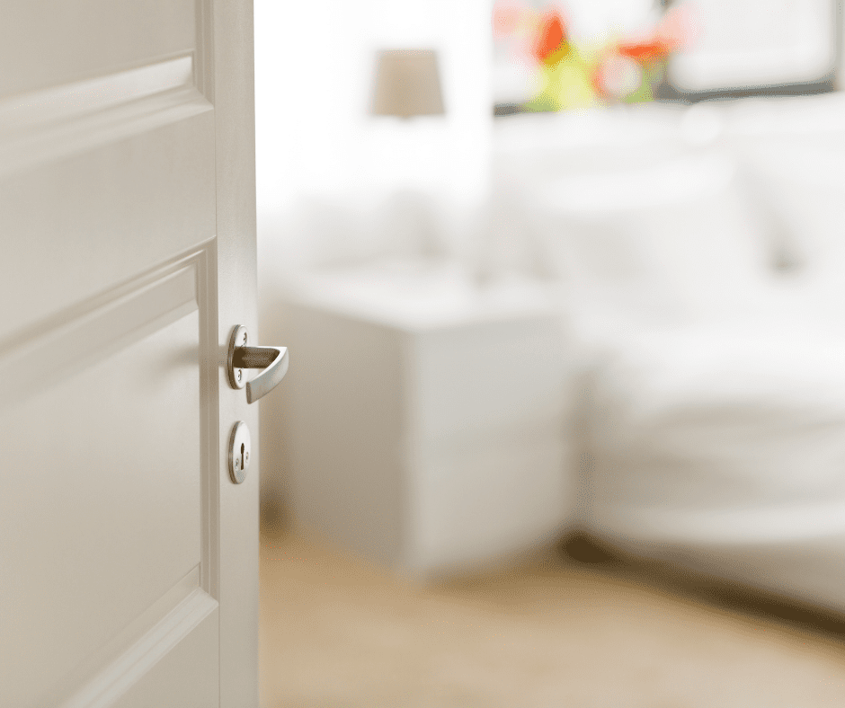 White bedroom door with blurred image of bed