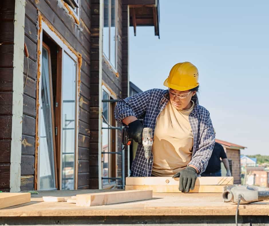 A woman working on wood using a drill