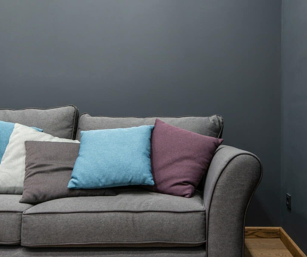 Gray couch in front of a gray wall