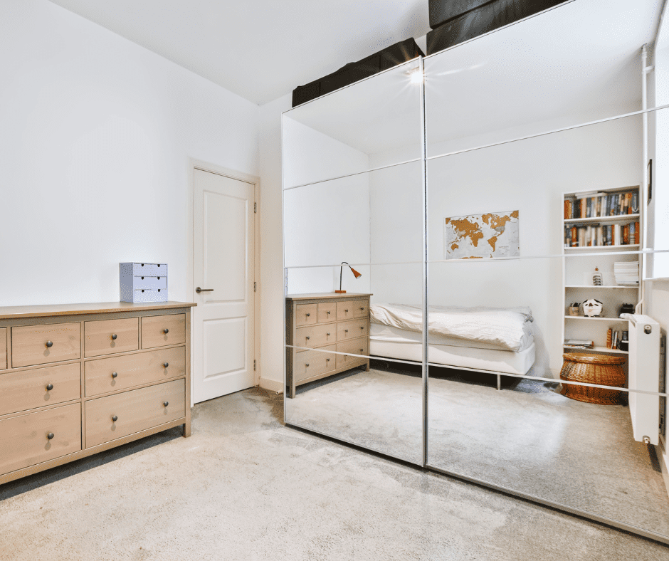 A bedroom cabinet with a sliding mirror door