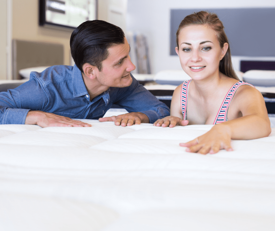 A couple checking out a mattress to buy