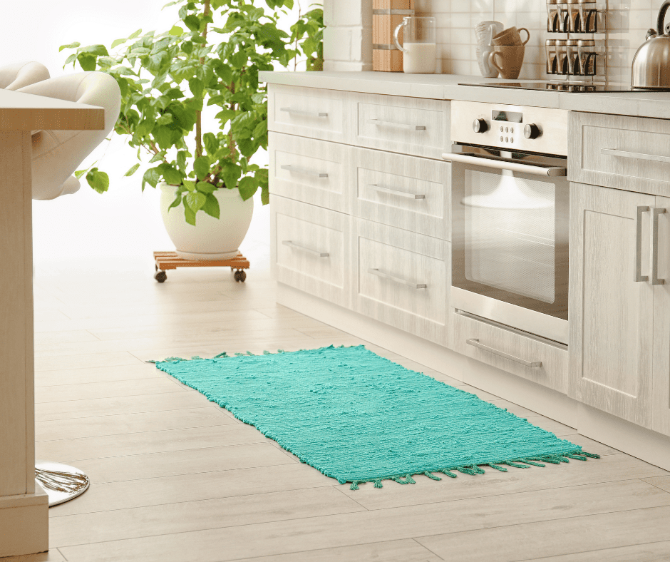 A green rug in front of the kitchen stove