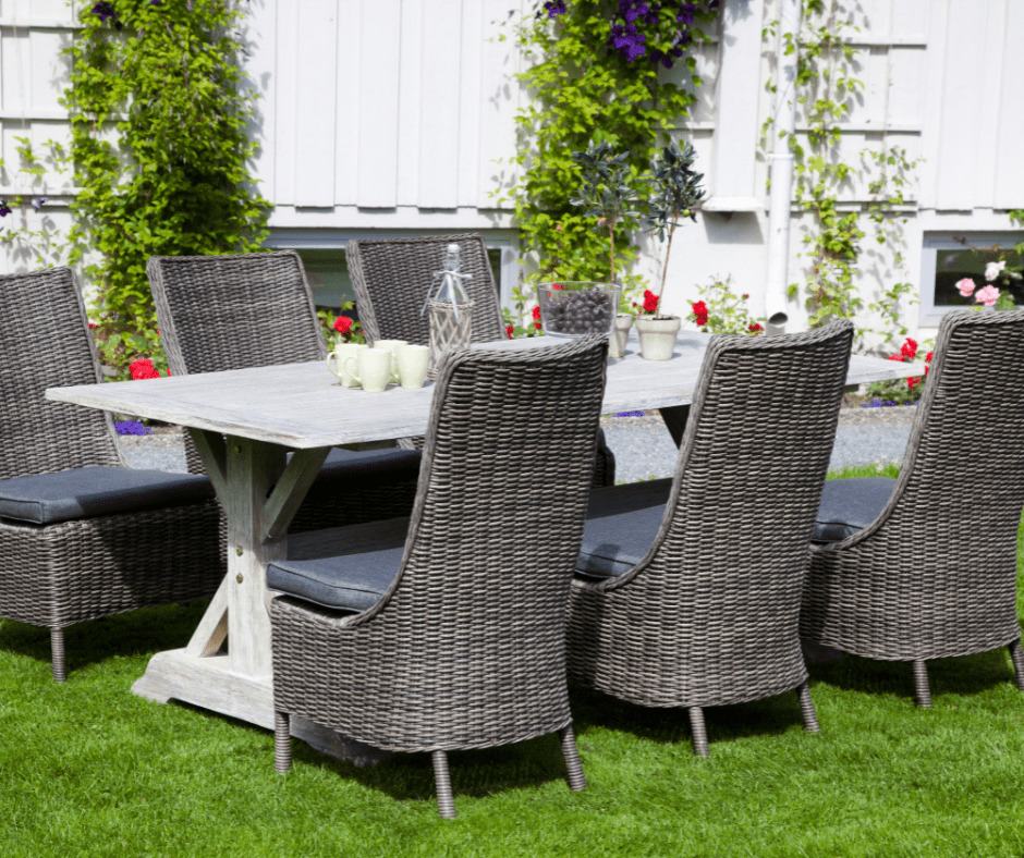 A garden dining set composed of wicker chairs and a wooden table