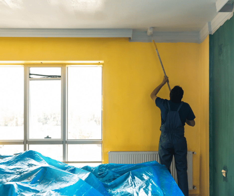 Man painting a ceiling with a roller