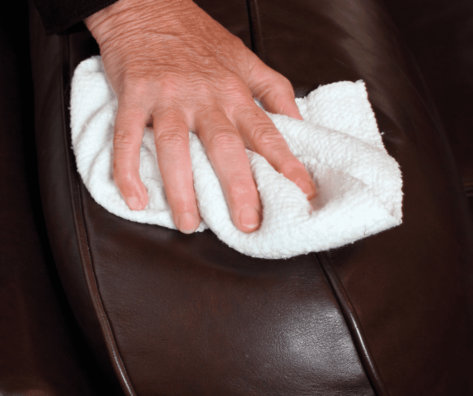 Wiping soap off leather couch with white rag