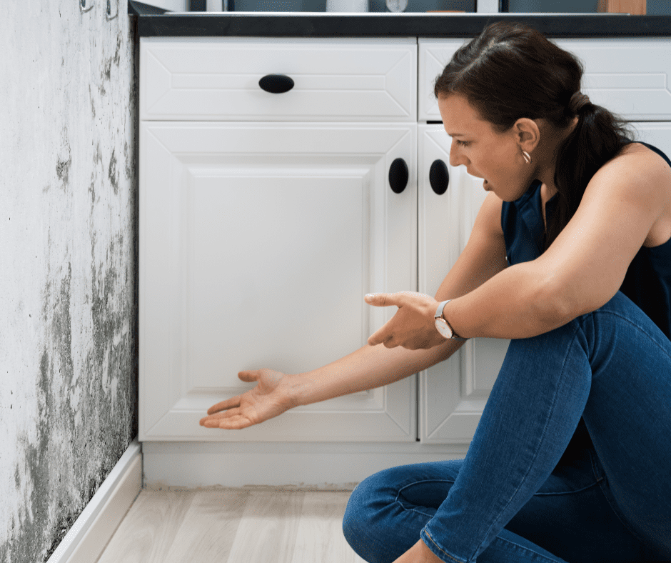 A woman disgusted by molds on a wall