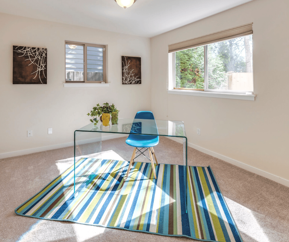 Home office with colorful rug on carpeted floor