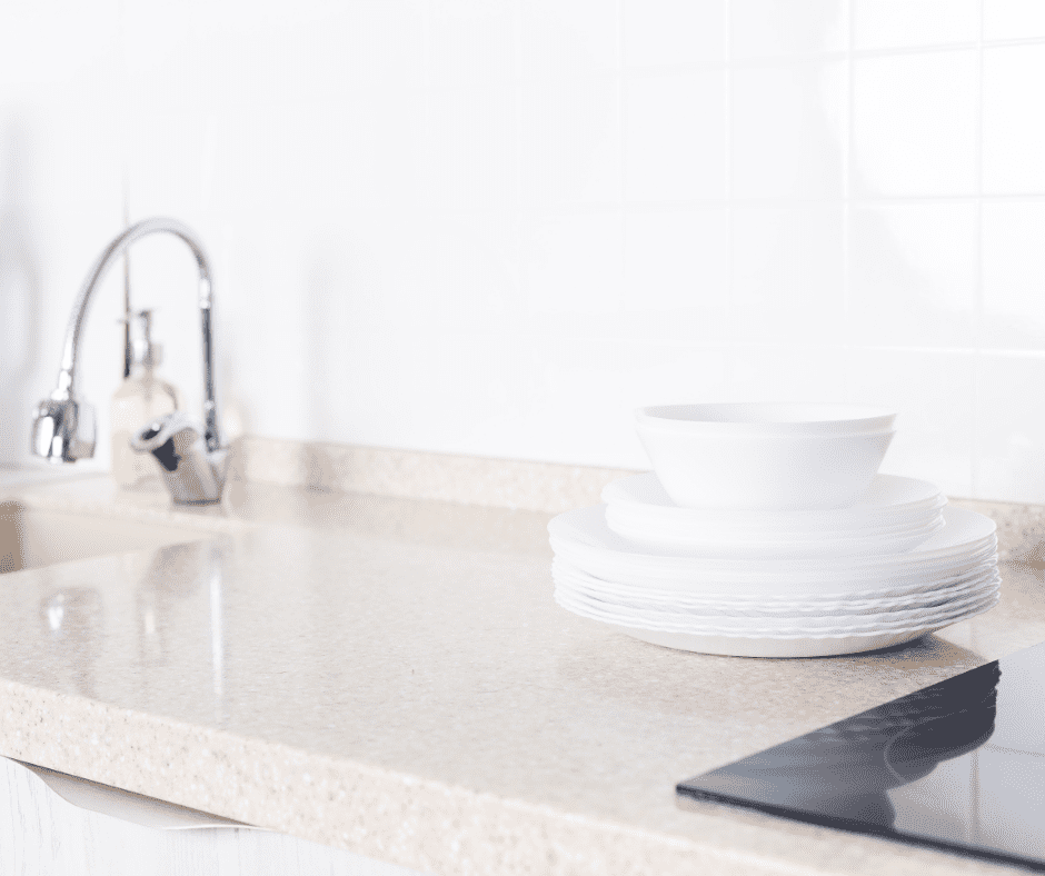 Clean dishes on top of a white granite countertop