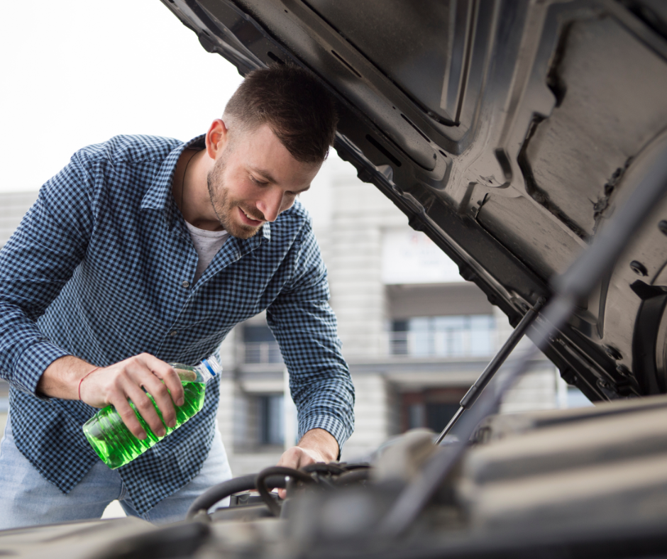 A man about to pour coolant in a car